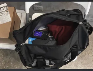 Vue détaillée du sac de sport noir avec un grand compartiment intérieur et design.