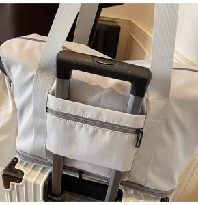 Detailaufnahme der Reisetasche mit praktischer Koffergriff-Halterung für bequemes Reisen.