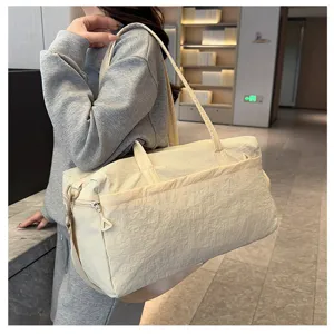 Detailed view of the large capacity beige gym duffel bag, showing fabric texture and strap.