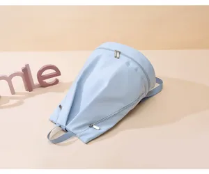 Dettaglio dello zaino da viaggio in tessuto oxford blu chiaro con cerniere e cinghie.