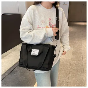 Black expandable gym travel shoulder bag detail view with handle and strap design.