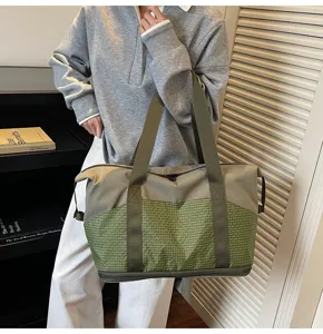 Detailansicht der Reisetasche mit strapazierfähigem Karomuster und stabilen Tragegriffen.