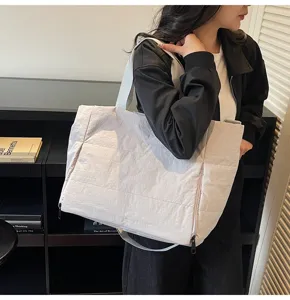 Details of the lightweight quilted tote bag showing large capacity and side zipper pocket.
