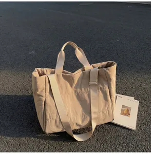 Minimalist large capacity quilted tote bag with adjustable strap for daily commute and sports.