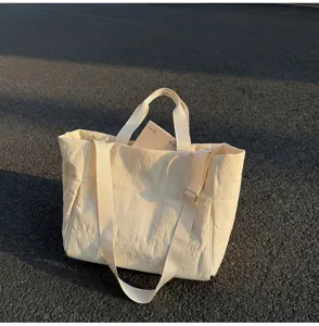Casual minimalist beige puffer tote bag with large capacity and adjustable strap for daily use.
