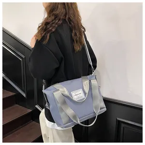 Small grey blue fitness travel shoulder bag detail view with wide silver straps and brand tag.