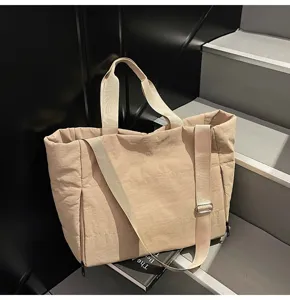 Detailed view of large capacity beige tote bag with shoulder strap, simple daily style.