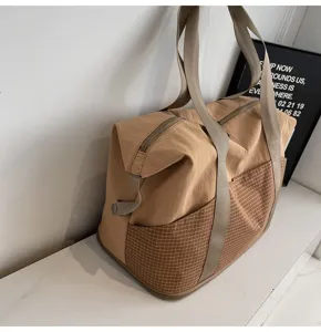 Große Reisetasche Detail, khaki Nylonstoff mit stilvoller brauner Karotasche für Alltag.