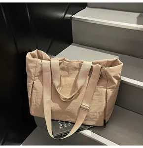 Detail view of large capacity minimalist tote bag, shoulder strap and sturdy handle design.