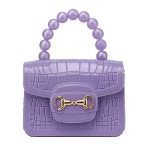 Lila PVC Gelee Handtasche mit KrokodilMuster, Perlenhenkel und goldenen Beschlägen.