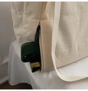 Close-up detail of side zipper pocket on minimalist quilted tote bag with spacious storage.