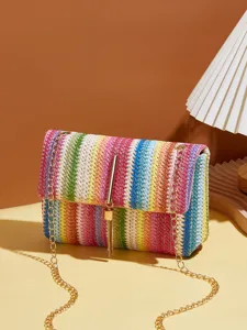 Detailaufnahme der bunten geflochtenen Stroh Umhängetasche mit goldener Kette und Quaste.