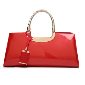 Red patent leather handbag with metallic braided handle, elegant evening bag for women.