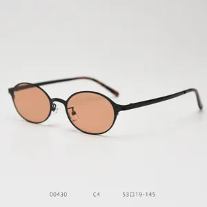 Gros plan de lunettes de soleil en métal ovale rétro avec monture fine et verres.