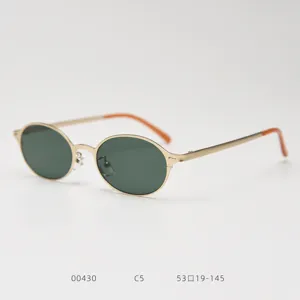Vue détaillée de lunettes de soleil en métal ovale rétro avec des verres verts et oranges.