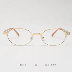 Monture de lunettes optiques en métal au design ovale rétro, finition dorée et verres clairs.