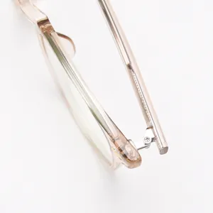 Primer plano detallado de la bisagra y varillas de montura de gafas de acetato transparente.