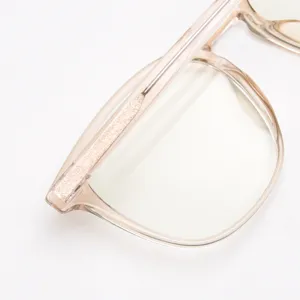 Primer plano detallado de la elegante montura de gafas de acetato rosa translúcido con varillas.
