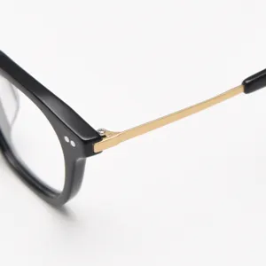 Detail shot of black acetate frame with gold titanium temple and classic double rivet.