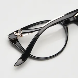 Close-up detail of women's cat-eye glasses frame, black TR90 and gold accent with butterfly.