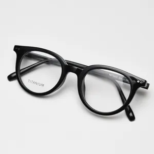 Close-up of black round titanium eyeglasses frame, vintage style optical glasses detail.