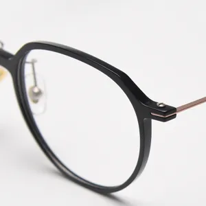 Close-up detail view of stylish black round eyeglass frame featuring slim metal temples.