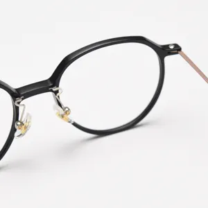 Close-up detail of lightweight thin-rimmed round optical glasses frame, premium black finish.