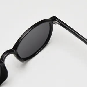 Close-up detail of black round vintage TR90 sunglasses, highlighting precise hinge craftsmanship.