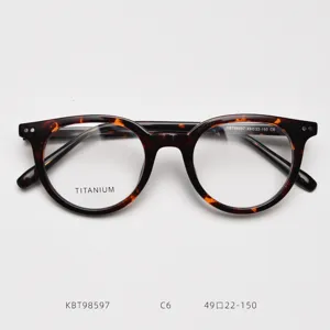 Close-up detail of tortoise shell round eyeglasses frame, premium optical eyewear structure.