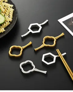 Stainless steel chopstick rest detailed view, elegant gold and silver tableware design for home.