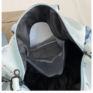 Interior detail of light blue travel duffel bag with waterproof compartment and star pattern.
