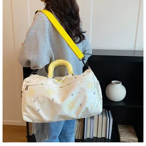 Large capacity travel duffel bag with bright yellow handles and shoulder strap for women.