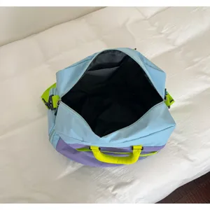 Color-contrast travel duffel bag detail, showing the spacious interior lining and top opening.