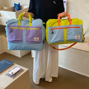 Colorblock travel duffel bag with large capacity, expandable design for gym and business trips.