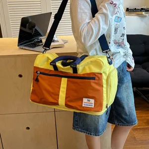 Color-block travel duffel bag detail showing durable shoulder strap, front pocket, and stylish.