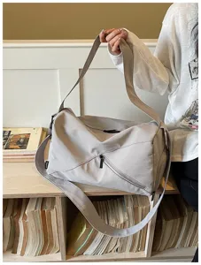 Sac de voyage gris décontracté avec lignes géométriques, sac bandoulière élégant pour usage.