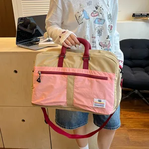 Detailed view of the color-blocked travel duffel bag showing durable zippers and handle.