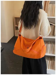 Sac de voyage sport en toile orange, détail de bandoulière, style décontracté usage quotidien.