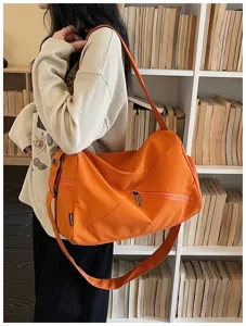 Sac de voyage de sport orange pour femme, grand sac bandoulière en toile avec poche zippée.