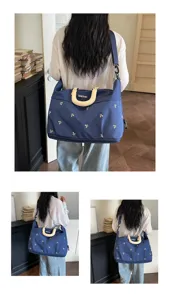 Geborduurde reistas detail, grote capaciteit crossbody en schoudertas voor korte reizen.