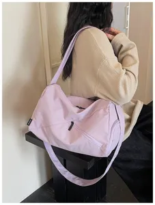 Vue détaillée d'un sac de voyage violet clair montrant la texture du tissu et la sangle réglable.