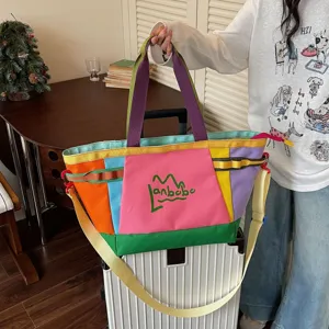 Colorful patchwork tote bag detail showing canvas texture, sturdy handles and shoulder strap.