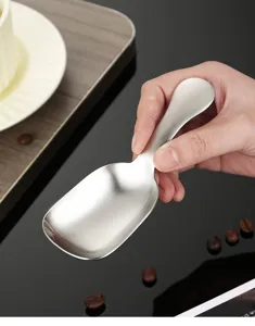 Detailopname van de geborstelde roestvrijstalen koffieboonschep met korte handgreep lepel.