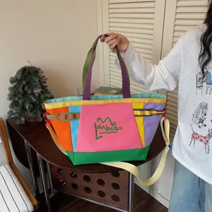 Detail view of color block canvas tote bag with adjustable straps and multi-color design.