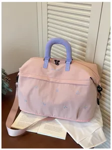 Roze reistas met schattige strik borduursel en comfortabele paarse handvatten.