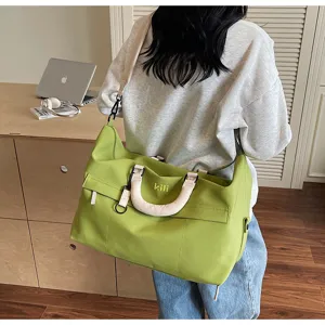 Detailed view of large capacity green travel duffle bag with comfortable handles and strap.