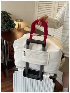 Grote capaciteit canvas reistas met rood handvat en trolleyhoes voor reizen en bagage.