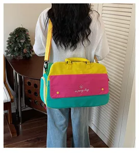 Detail view of the colorful dopamine color block travel bag, showing back carry and fabric texture.