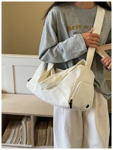 Détail de sac de voyage en toile blanche avec bandoulière robuste et grand rangement.