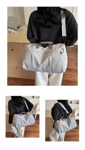 Vue détaillée du grand sac de voyage et de sport gris clair avec bandoulière réglable.
